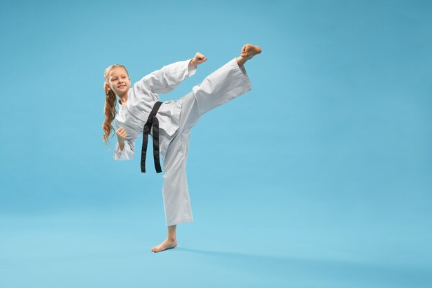 Karate dziewczyna w białym kimonie uprawiającym sztuki walki.