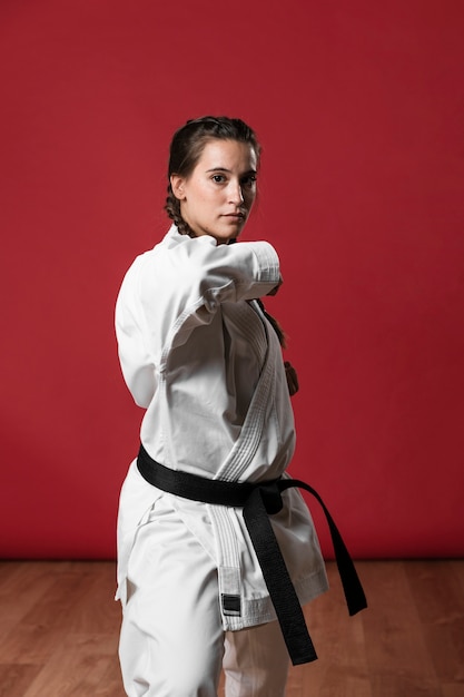 Karate kobieta w akci odizolowywającej w czerwonym tle