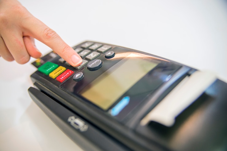 Bezpłatny plik Zdjęcie karta płatnicza w terminalu bankowym. pojęcie płatności elektronicznej. ręczny kod pin na stykowej karcie karty lub maszyna terminalu dobry dobry