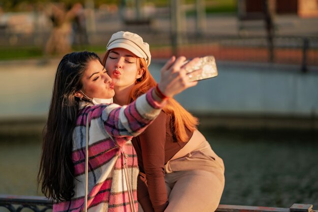 Kaukaskie koleżanki robią selfie w parku