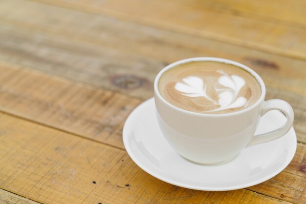 Kawa latte sztuki na drewnianym stole