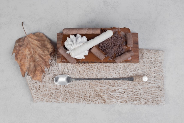 Kawałek ciasta czekoladowego z liściem i łyżką na marmurowym stole. Wysokiej jakości zdjęcie