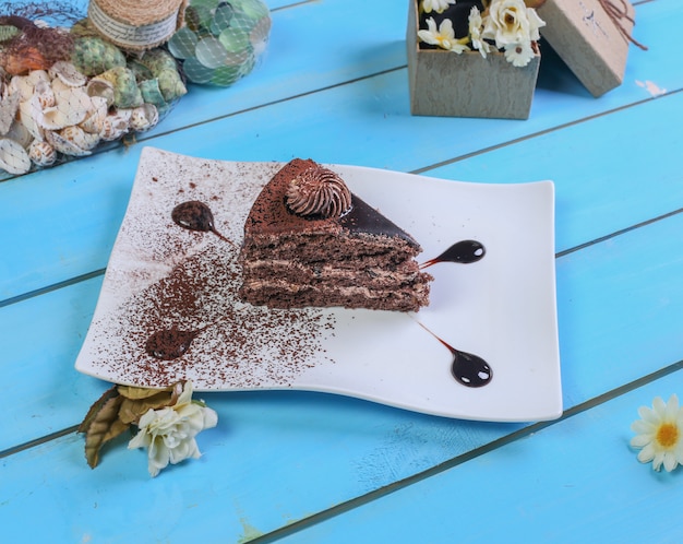 Kawałek ciasta czekoladowego z proszkiem kakaowym.