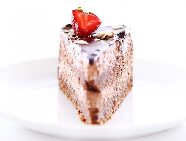 Kawałek smacznego ciasta czekoladowego z truskawkami na wierzchu
