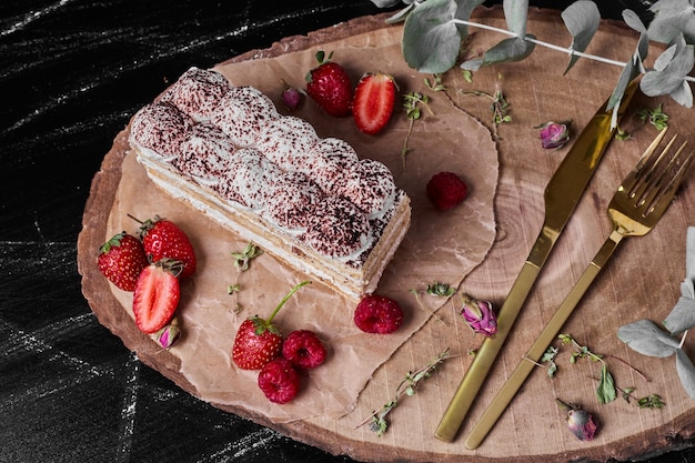 Bezpłatne zdjęcie kawałek tiramisu na drewnianym talerzu.