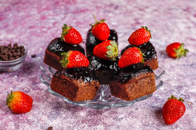 Kawałki ciasta czekoladowego z sosem czekoladowym i owocami, jagodami.