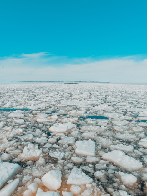 kawałki lodu w zamarzniętym jeziorze pod jasnym niebem w zimie
