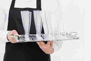 Bezpłatne zdjęcie kelner gospodarstwa puste szklanki na tacy