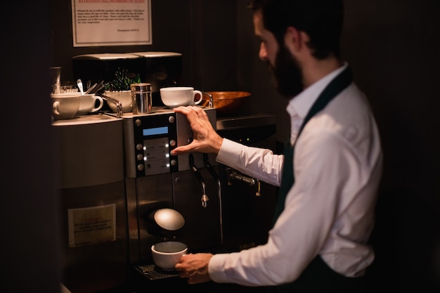 Kelner parzenia kawy z ekspresu do kawy