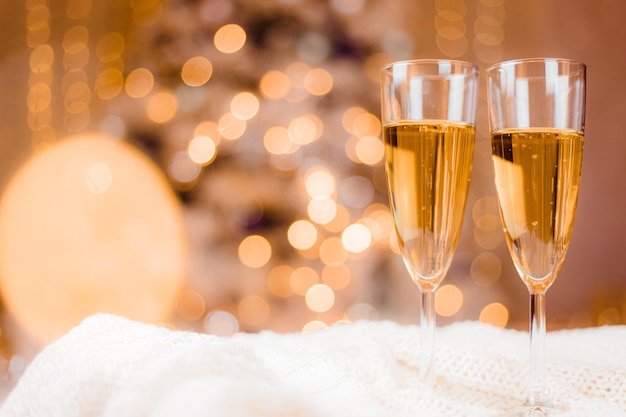 Kieliszki do szampana na tle choinki. świąteczne napoje. napoje alkoholowe.