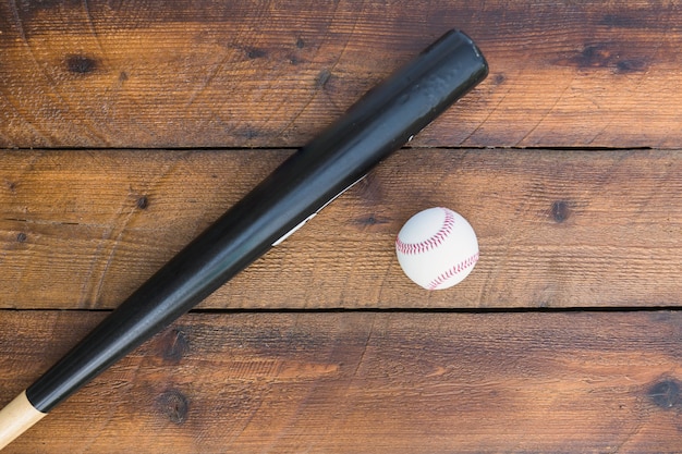 Bezpłatne zdjęcie kij bejsbolowy i baseball na drewnianym stole