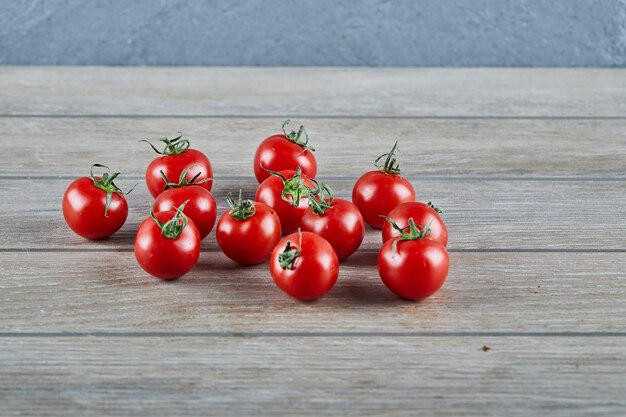 Kilka świeżych soczystych pomidorów na drewnianym stole.