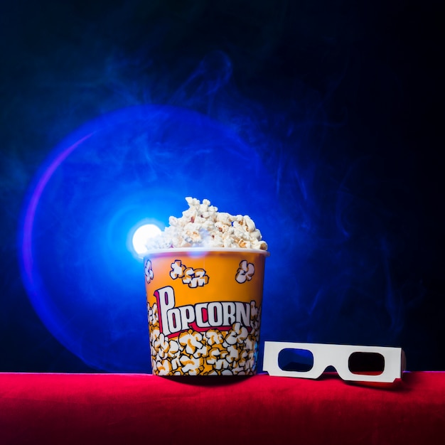 Bezpłatne zdjęcie kino z pudełkiem popcornu i okularami 3d