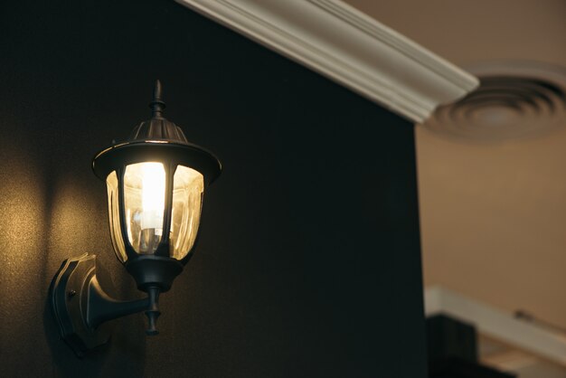 Klasyczna lampa na czarnej ścianie.