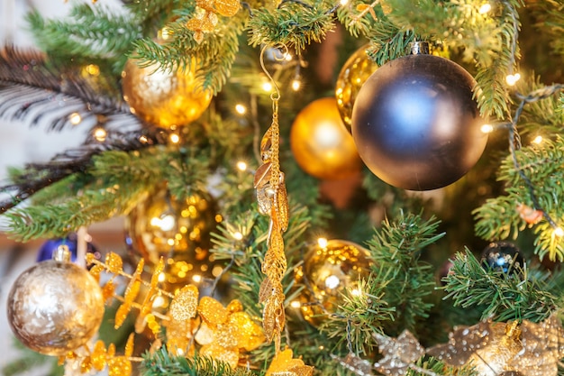 Klasyczne boże narodzenie nowy rok ozdobione nowy rok drzewo ze złotym ornamentem ozdoby zabawki i piłkę. nowoczesny biały apartament w stylu klasycznym. wigilia w domu