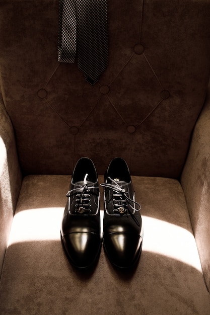 Klasyczne buty Grooma leżą na miękkim fotelu