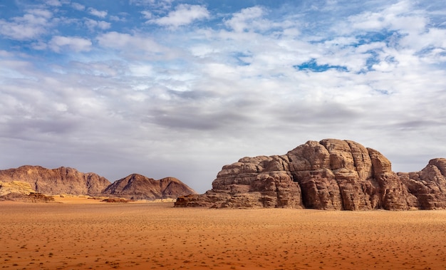 Klify i jaskinie na pustyni pełnej suchej trawy pod zachmurzonym niebem w ciągu dnia
