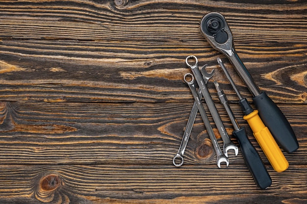 Klucze i inne narzędzia na ciemnym brązowym tle drewnianych. skopiuj miejsce