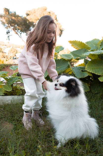 Bezpłatne zdjęcie kobiece dziecko i puszysty pies gra