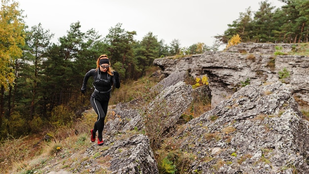 Kobiece jogger sportowy działa na kamieniach długie ujęcie