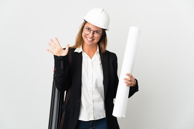 Kobieta architekt w średnim wieku z hełmem i trzymając plany na białym tle