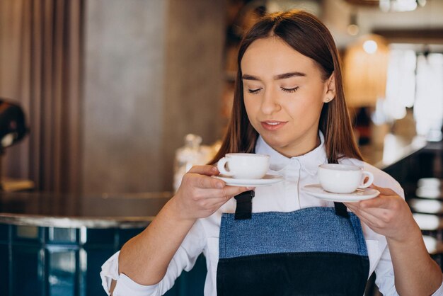 Kobieta barista w kawiarni trzymająca espresso