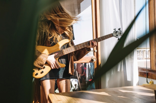 Kobieta bawić się gitarę w lekkim pokoju