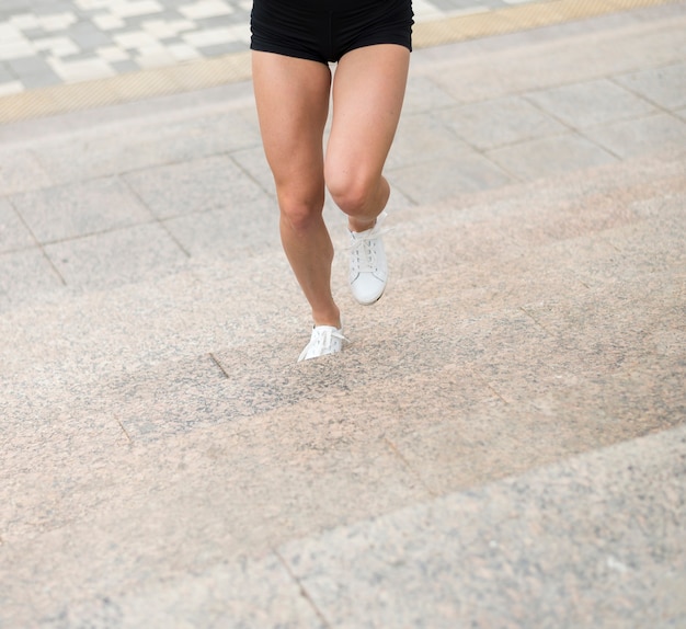 Bezpłatne zdjęcie kobieta biega w górę schodka niskiego kąta strzału