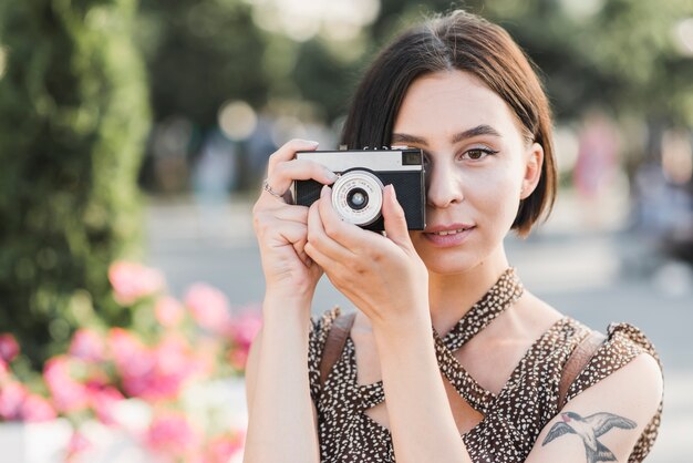 Kobieta bierze fotografię w parku z kamerą
