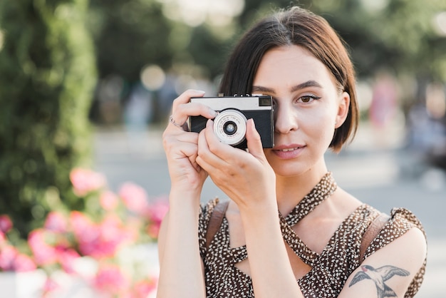 Kobieta bierze fotografię w parku z kamerą