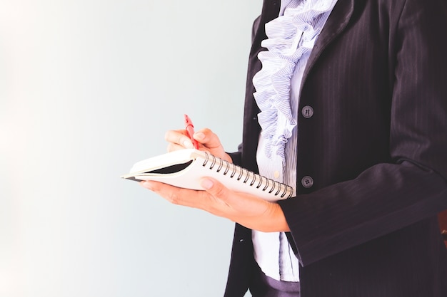 Kobieta biznesowych w ciemnym kolorze pisania na jej notebooka, koncepcji biznesowych z miejsca kopiowania