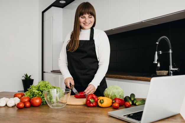 Kobieta blogerka przesyłania strumieniowego gotowania z laptopem