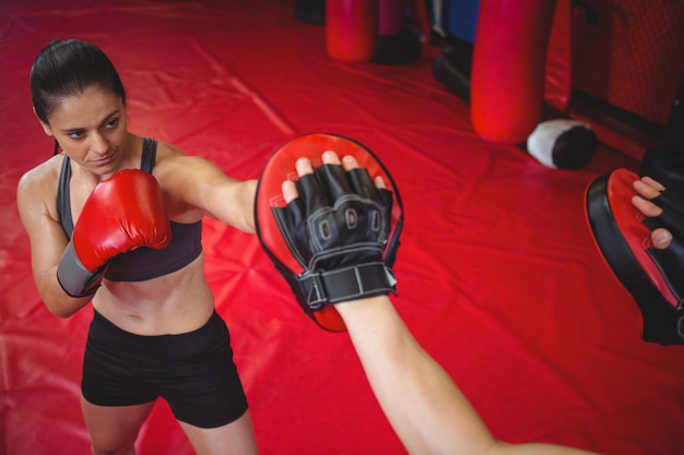 Kobieta bokser ćwiczy z trenerem