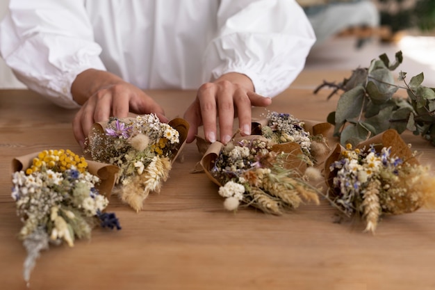 Bezpłatne zdjęcie kobieta budująca własną kompozycję suszonych kwiatów