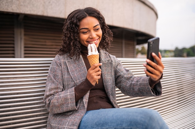 Bezpłatne zdjęcie kobieta buźka o lody na zewnątrz i przy selfie