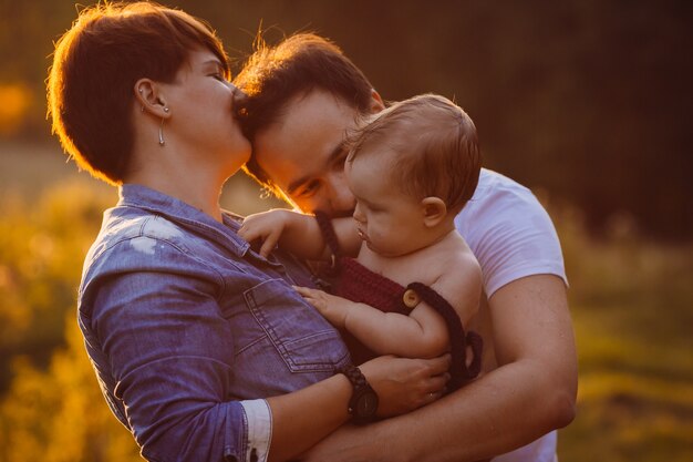 Kobieta całuje jej mężczyzna trzyma ich małej córki