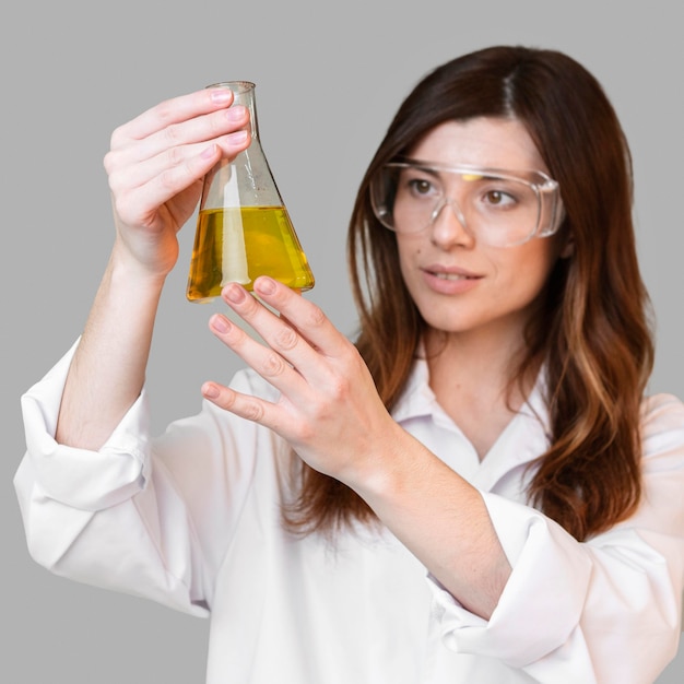 Kobieta chemik trzymając probówkę w okularach ochronnych