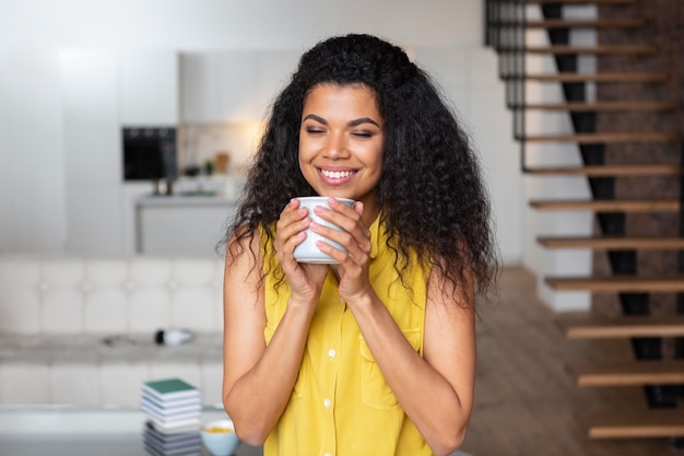 Bezpłatne zdjęcie kobieta, ciesząc się filiżanką kawy