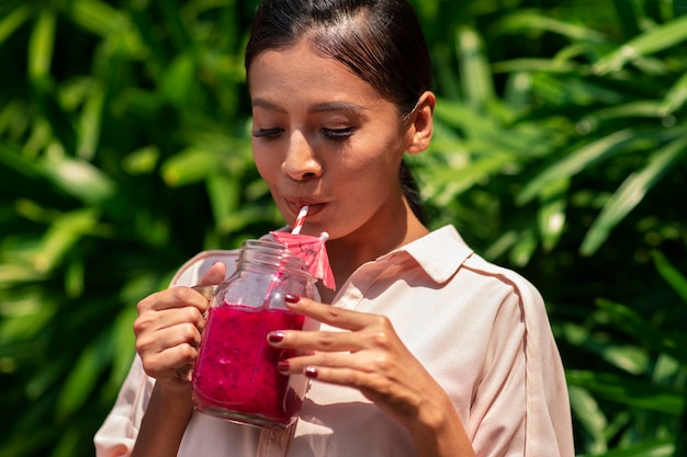 Kobieta ciesząca się napojem owocowym smoka na świeżym powietrzu