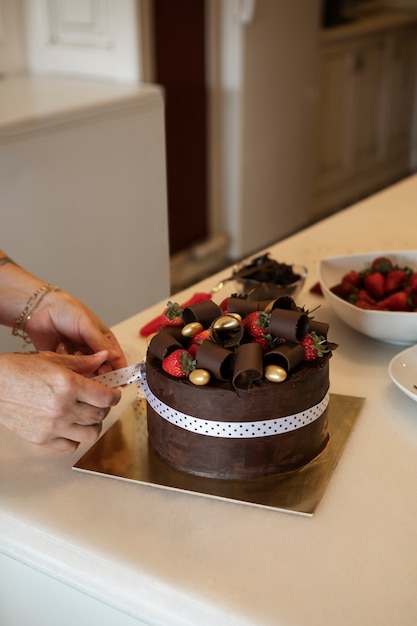 Bezpłatne zdjęcie kobieta cukiernik z ciastem czekoladowym w cukierni