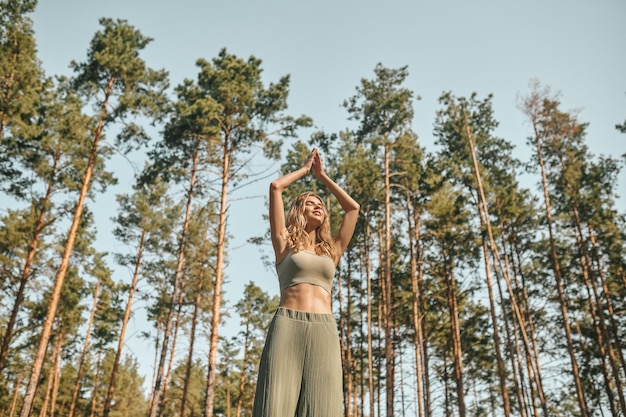 Kobieta ćwicząca jogę w parku i wyglądająca na zaangażowaną