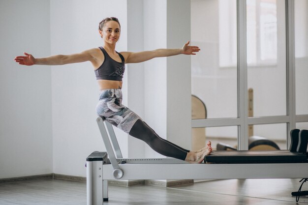 Kobieta ćwiczy pilates w reformatorze pilates