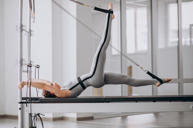 Kobieta ćwiczy pilates w reformatorze pilates