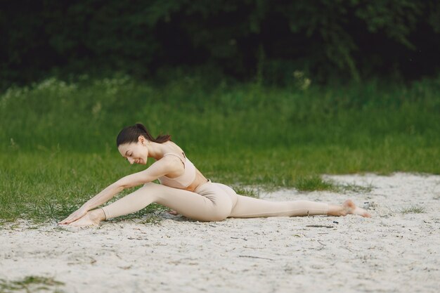 Kobieta ćwiczy zaawansowaną jogę na plaży