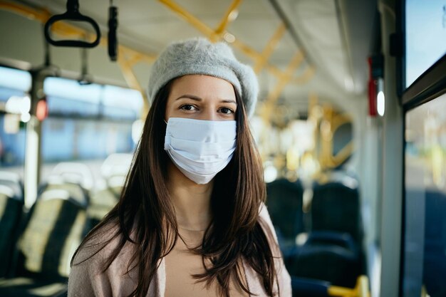 Kobieta dojeżdżająca do pracy nosząca maskę ochronną na twarz w transporcie publicznym