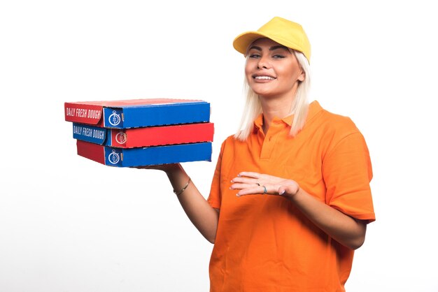 Kobieta dostawy pizzy trzymając pizzę na białym tle wyciągając ręce na bok. Wysokiej jakości zdjęcie