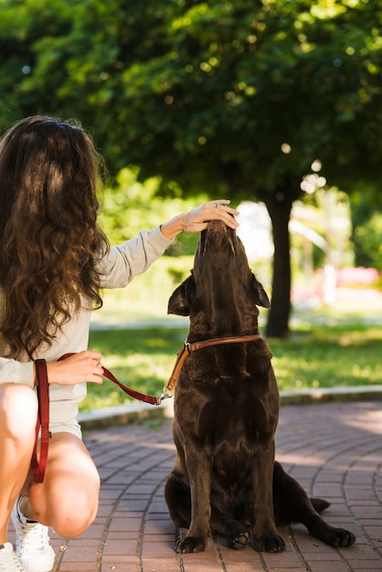 Bezpłatne zdjęcie kobieta dotyka psa usta w parku