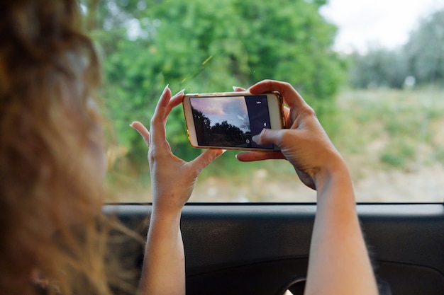 Bezpłatne zdjęcie kobieta fotografuje naturę na smartphone