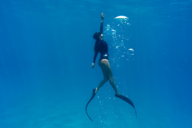 Kobieta freediving z płetwami pod wodą