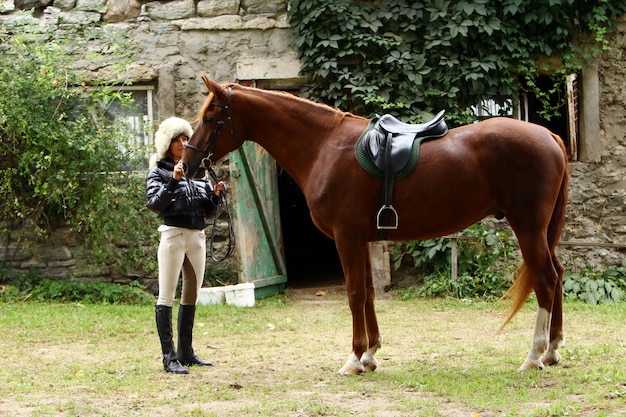 Bezpłatne zdjęcie kobieta i jej brązowy koń